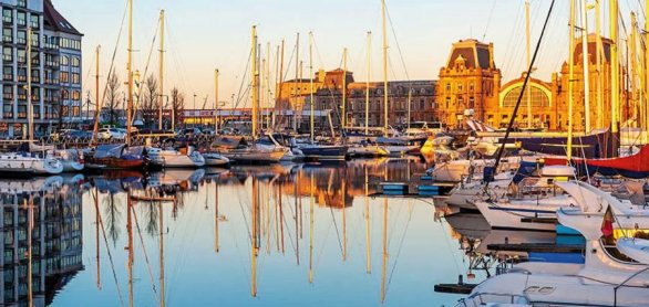 The yacht harbor of Oostende (Ostend) with train station at suns © SL-Photography - stock.adobe.com