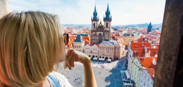 Young woman stands on top of clock tower and looks at Old Town S © LALSSTOCK - stock.adobe.com